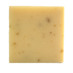 Square bar of soap with visible specks on a white background